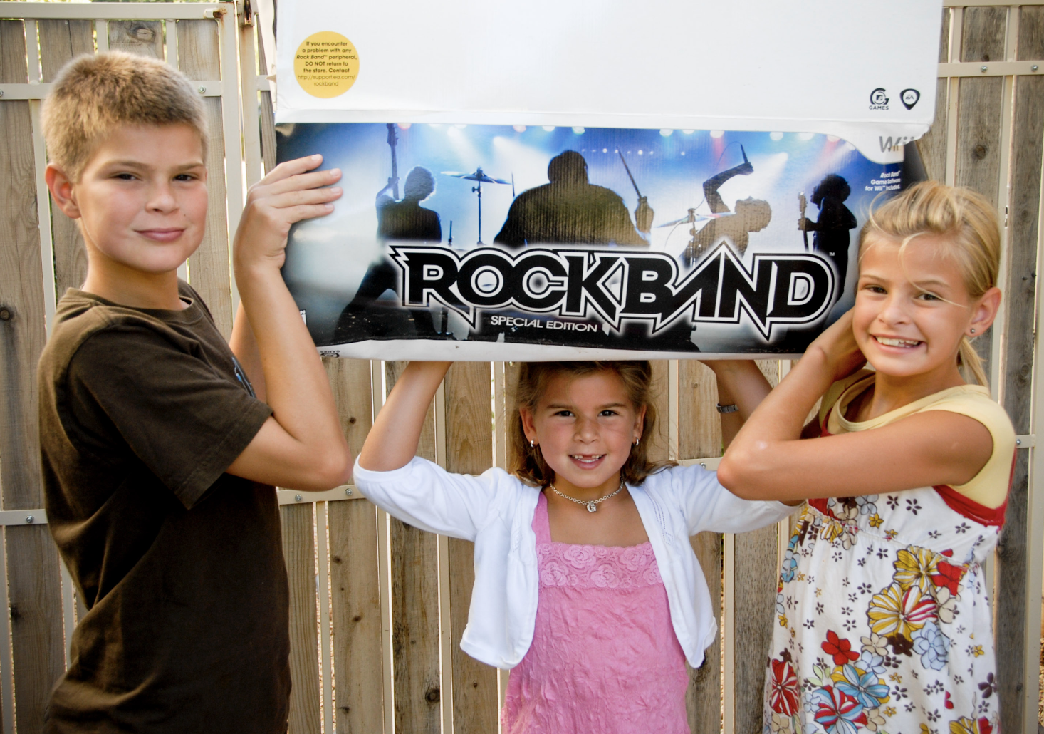 Max, Grace and Claire holding up their prized possession they earned together: Rockband