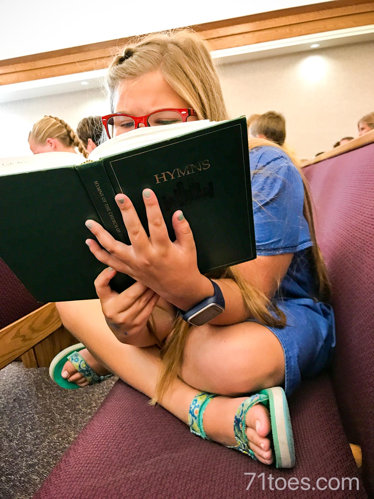 Lucy holding a hymn book at church