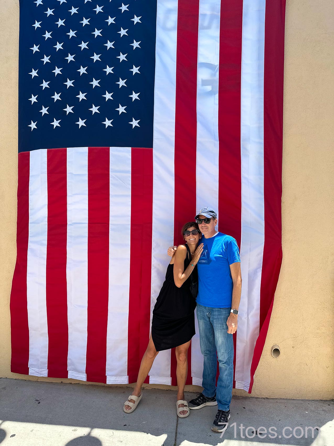 Shawni and Josh in front of a huge American flag